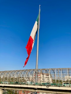 a flag on a pole next to a bridge