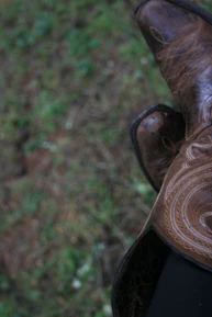Close-up of cowboy boots tapping rhythmically on a wooden dance floor.