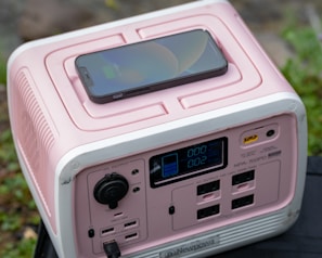 a pink and white electronic device sitting on top of a table