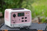 a pink and white radio sitting on top of a bag