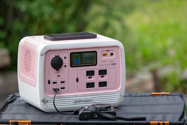 a pink and white radio sitting on top of a bag