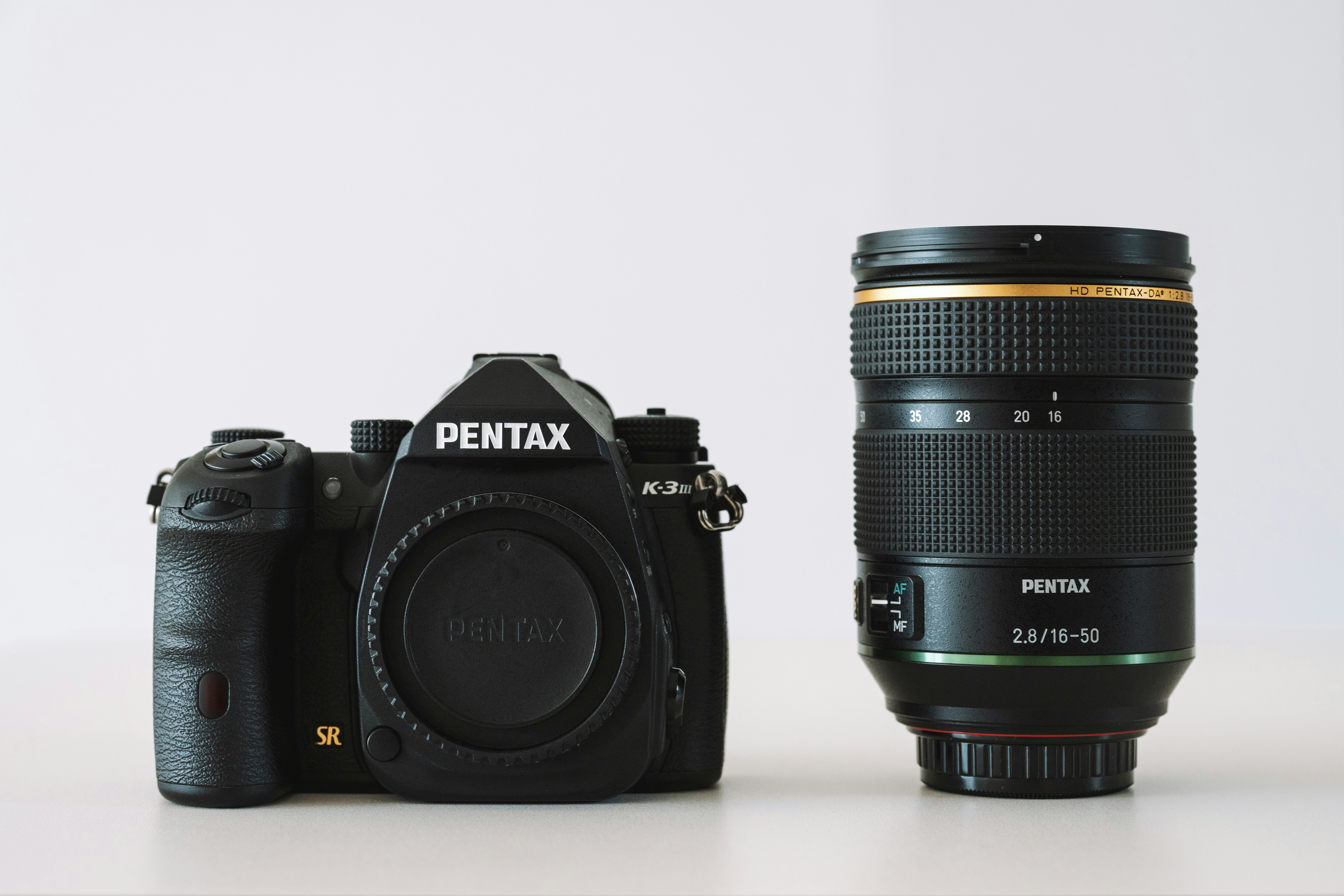 Una fotocamera accanto a un obiettivo su un tavolo