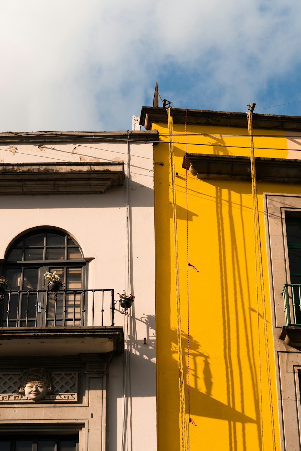 a tall yellow building with a balcony and balconies