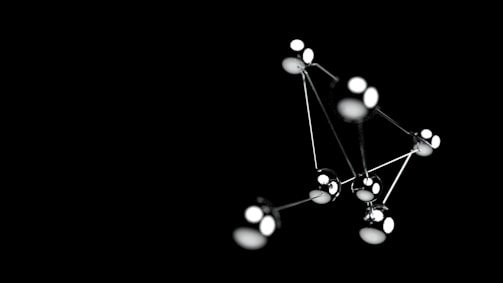 Minimalist sculpture made from polished metal reflecting light.