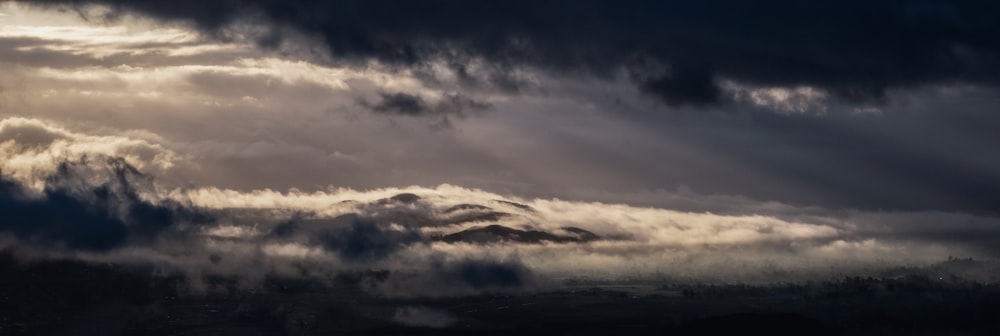 a cloudy sky with sunbeams shining through the clouds