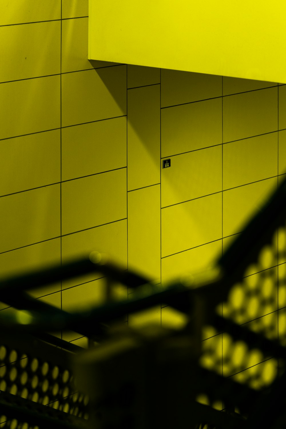 a shopping cart sitting in front of a yellow wall