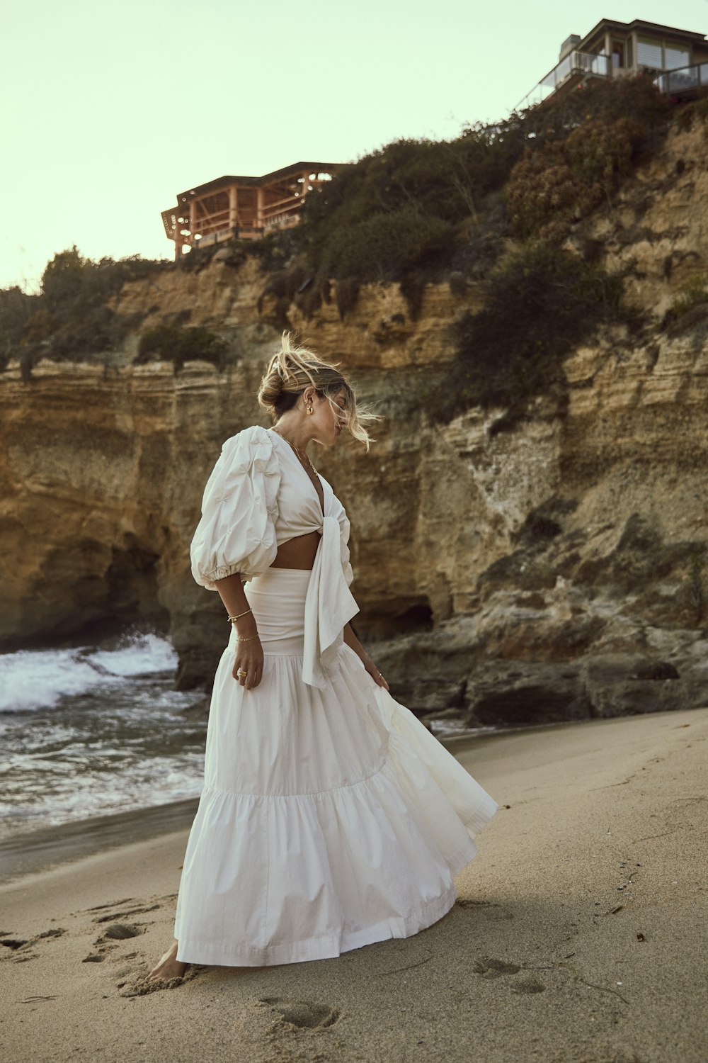 a woman standing on top of a sandy beach