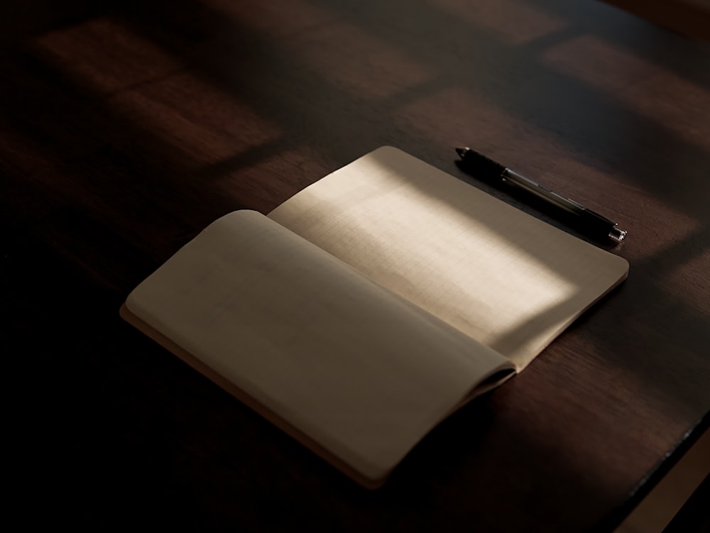 a notebook and pen on a wooden table