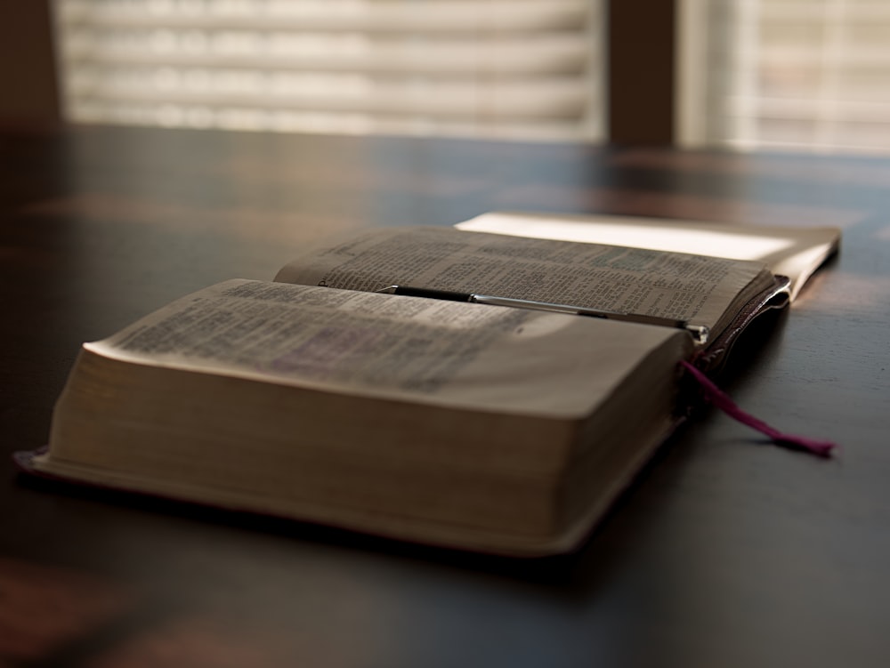 an open book sitting on top of a wooden table