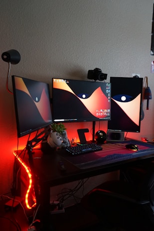 a computer desk with two monitors and a keyboard