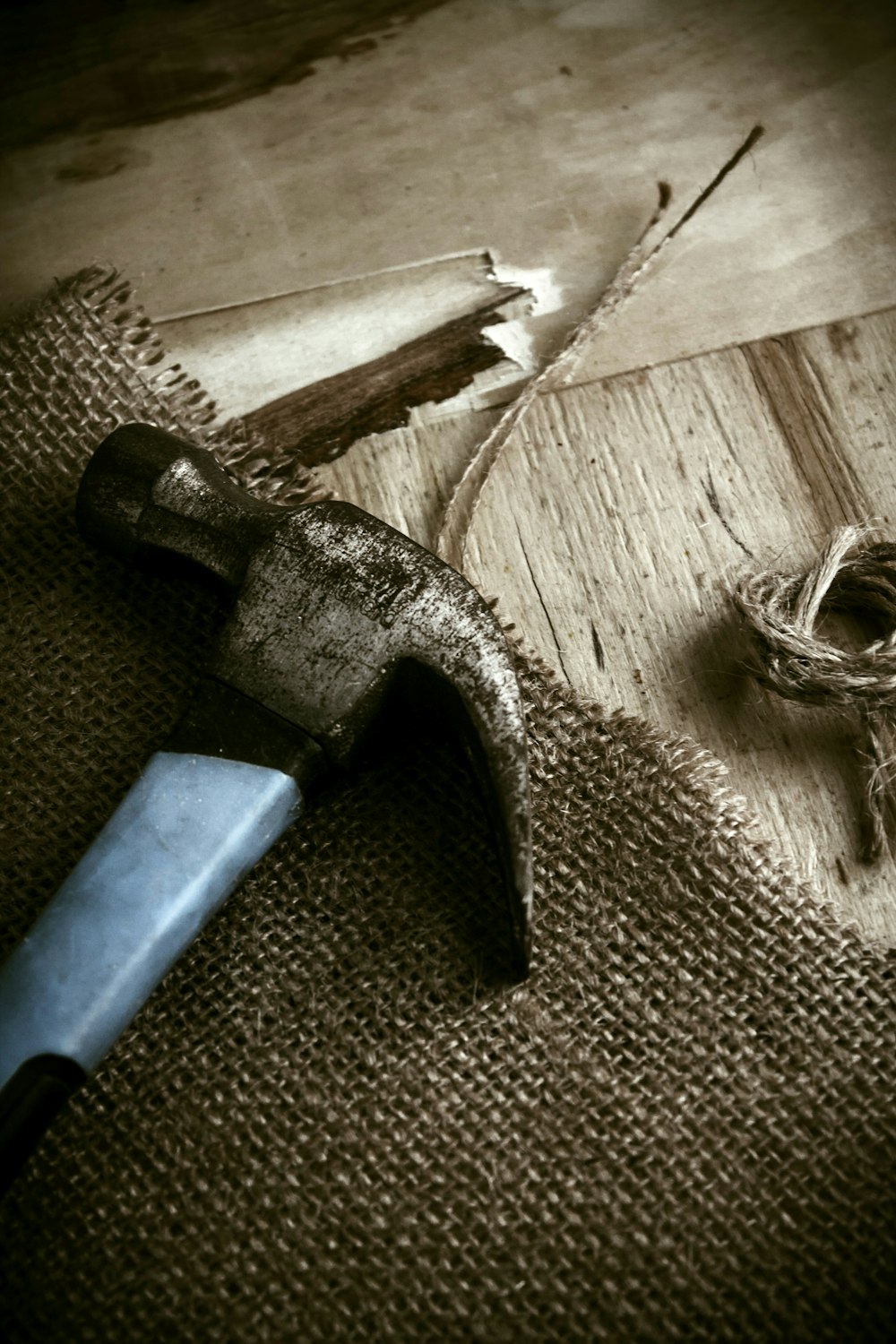 a hammer and a rope on a wooden floor