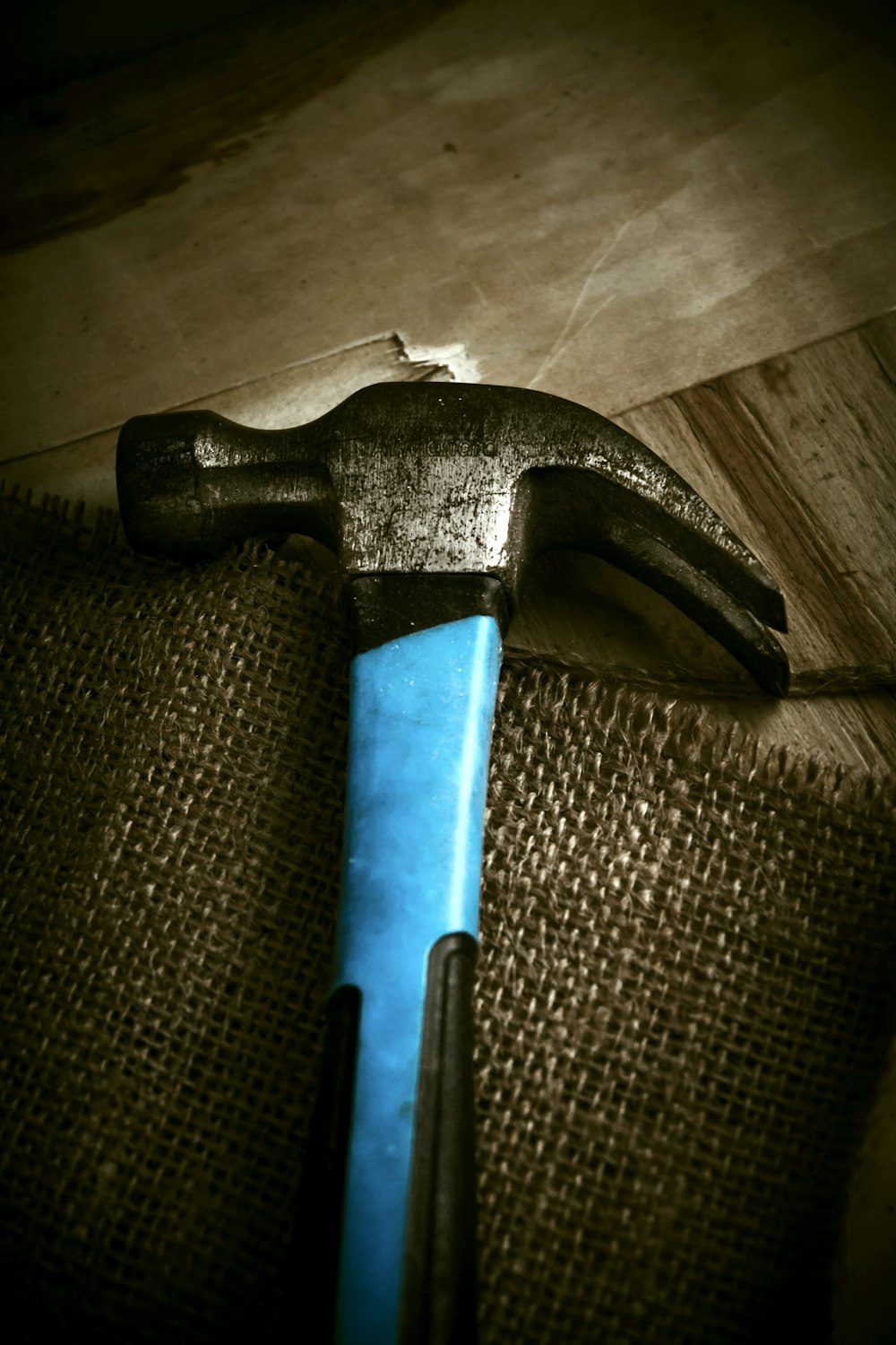 a hammer with a blue handle on a piece of wood