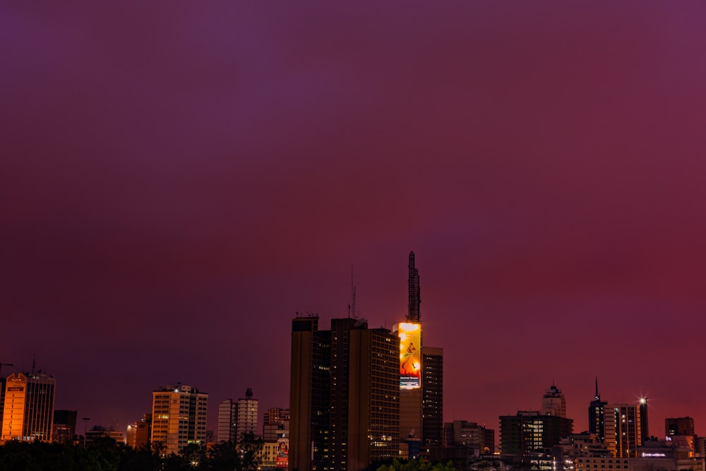 a city skyline at night with a purple sky