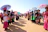 A vibrant scene of diverse families enjoying a colorful Chinese tea ceremony outdoors during a sunny community festival.