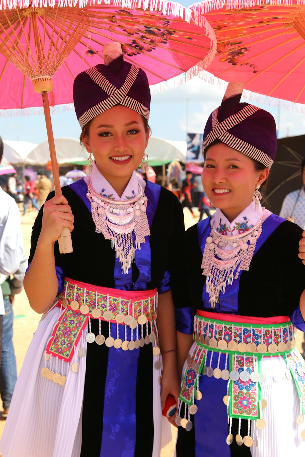 two asian girls in traditional dress holding umbrellas