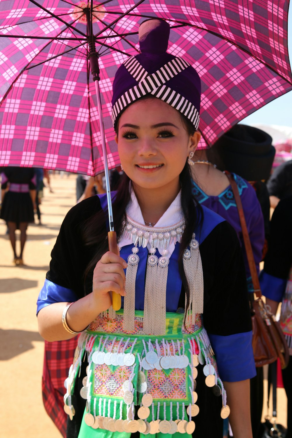 a young girl holding a pink umbrella on a sunny day