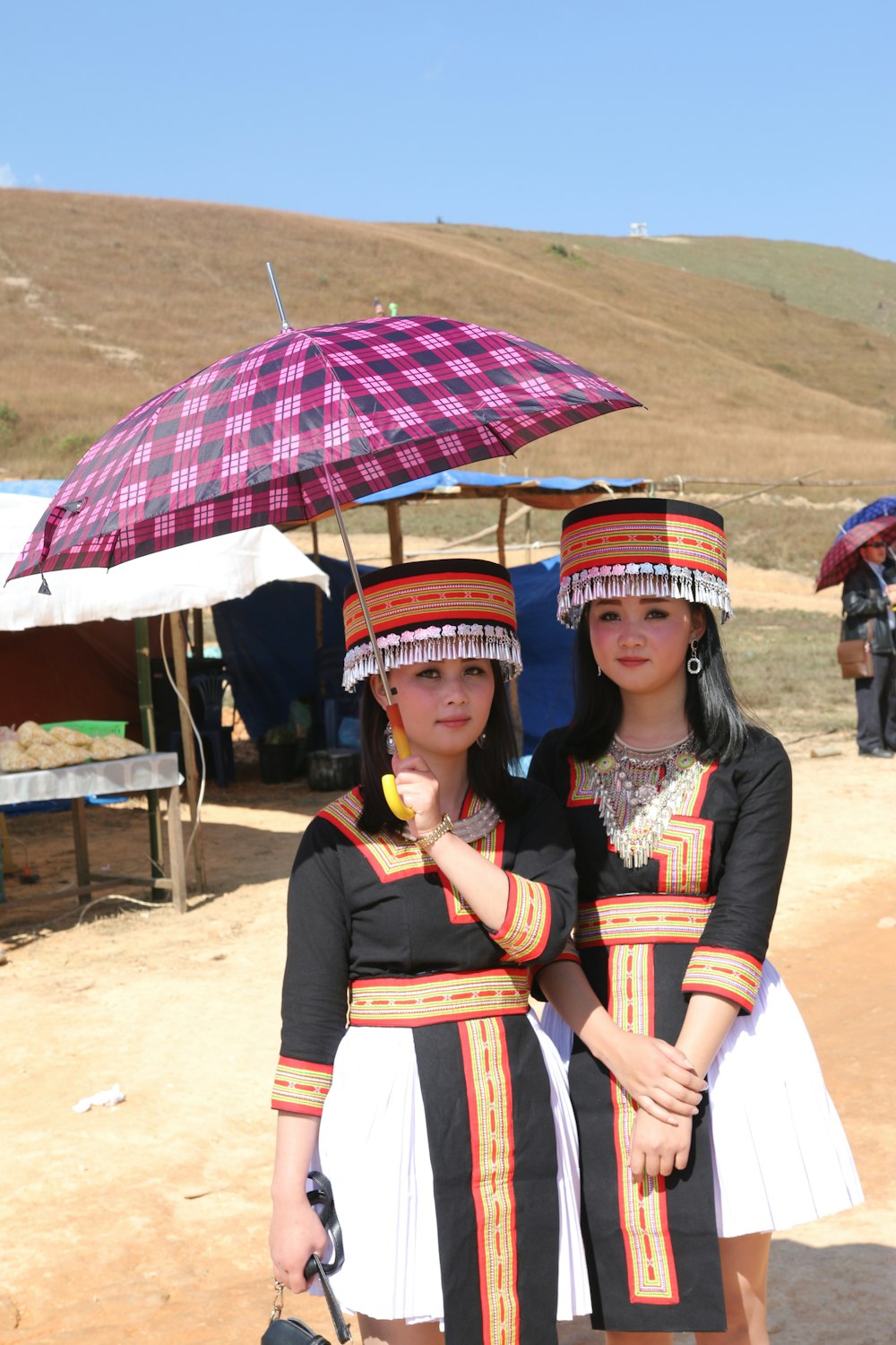 two asian women in traditional dress holding umbrellas