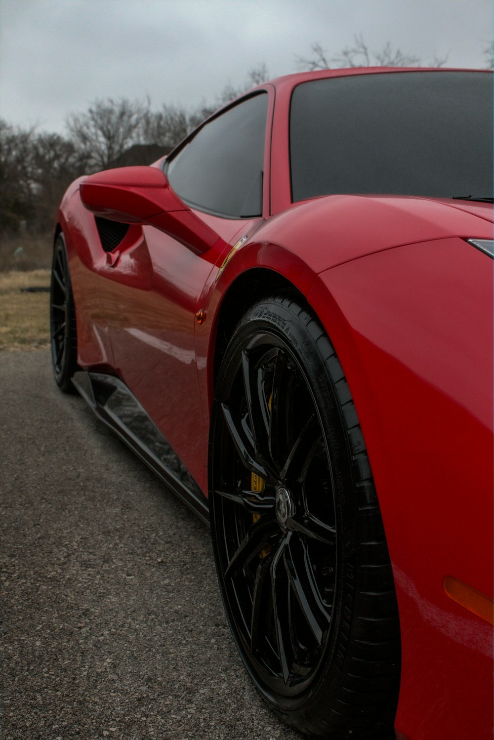 Une voiture de sport rouge garée sur le bord de la route