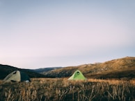 Tents set up on a grassy field under a clear sky.