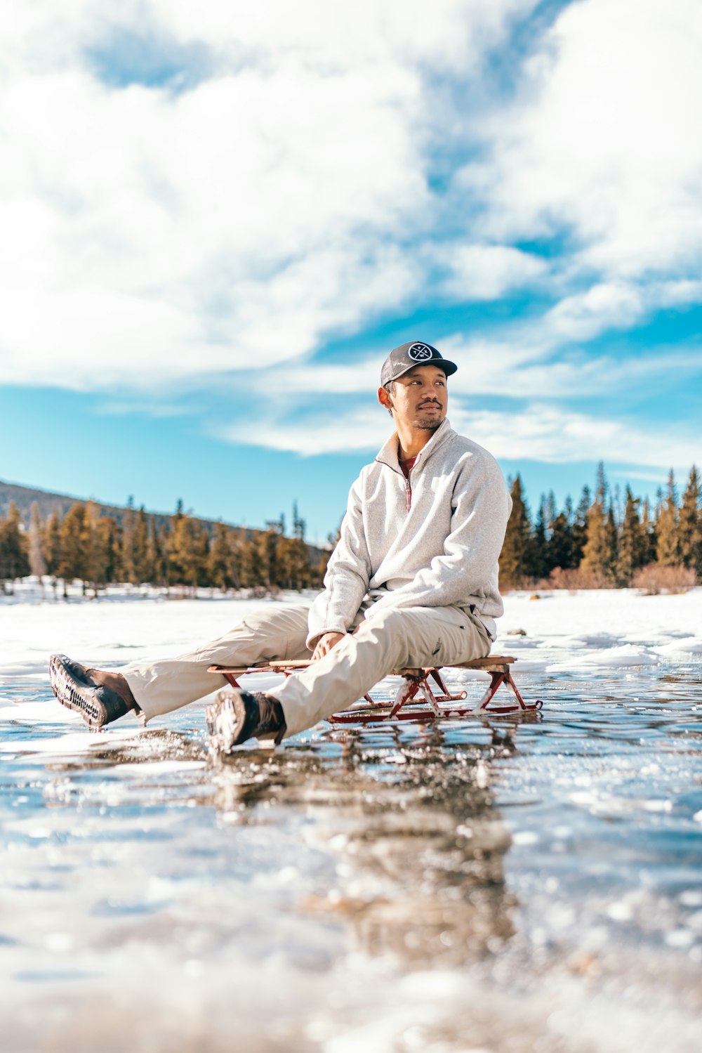 a man sitting on a sled in the water