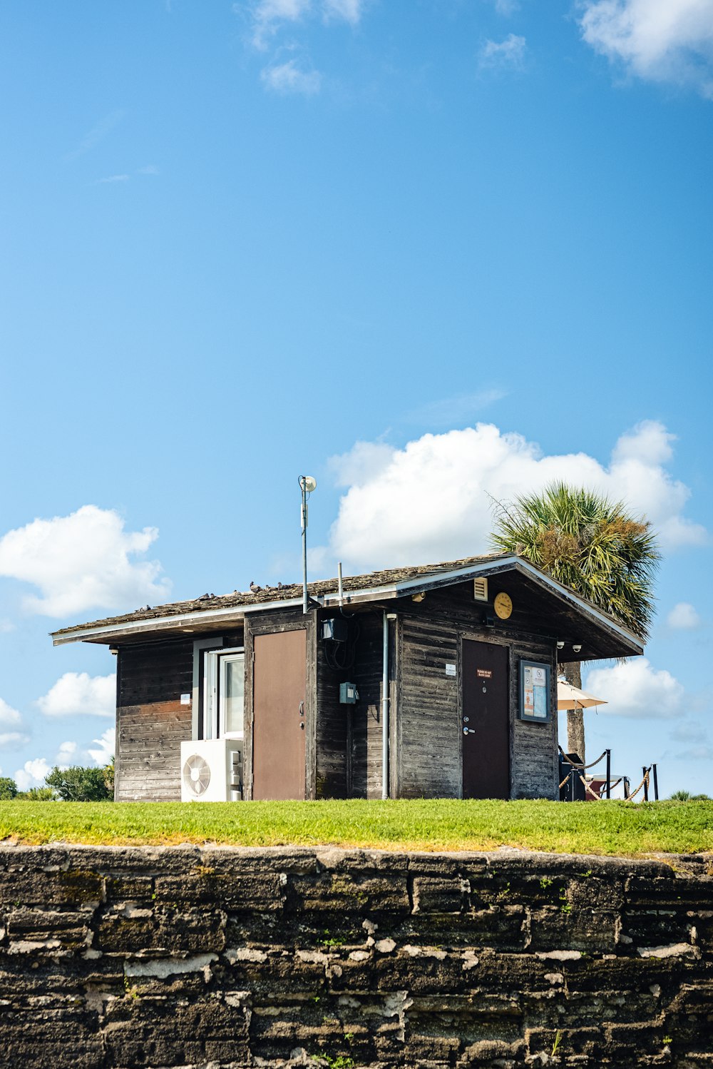 a small building sitting on top of a lush green field