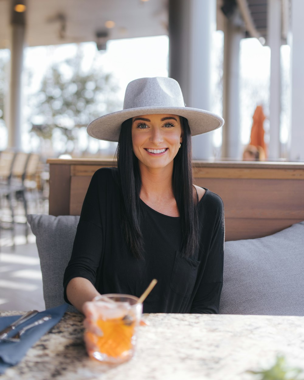 a woman sitting at a table with a drink