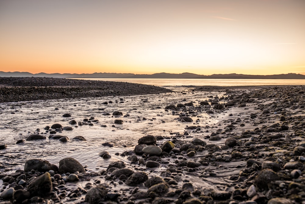 Le soleil se couche sur une plage rocheuse