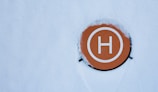 a circle with the letter h on it in the snow