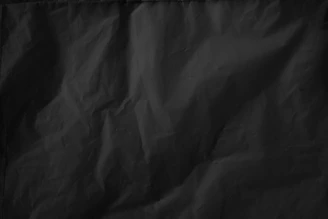 A subtle shadow texture with faint red veins weaving through a deep matte black background.