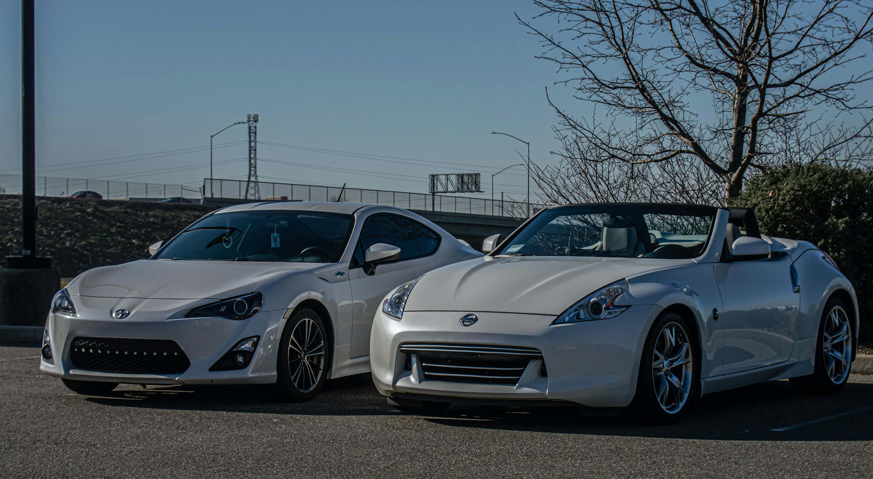two white sports cars parked next to each other