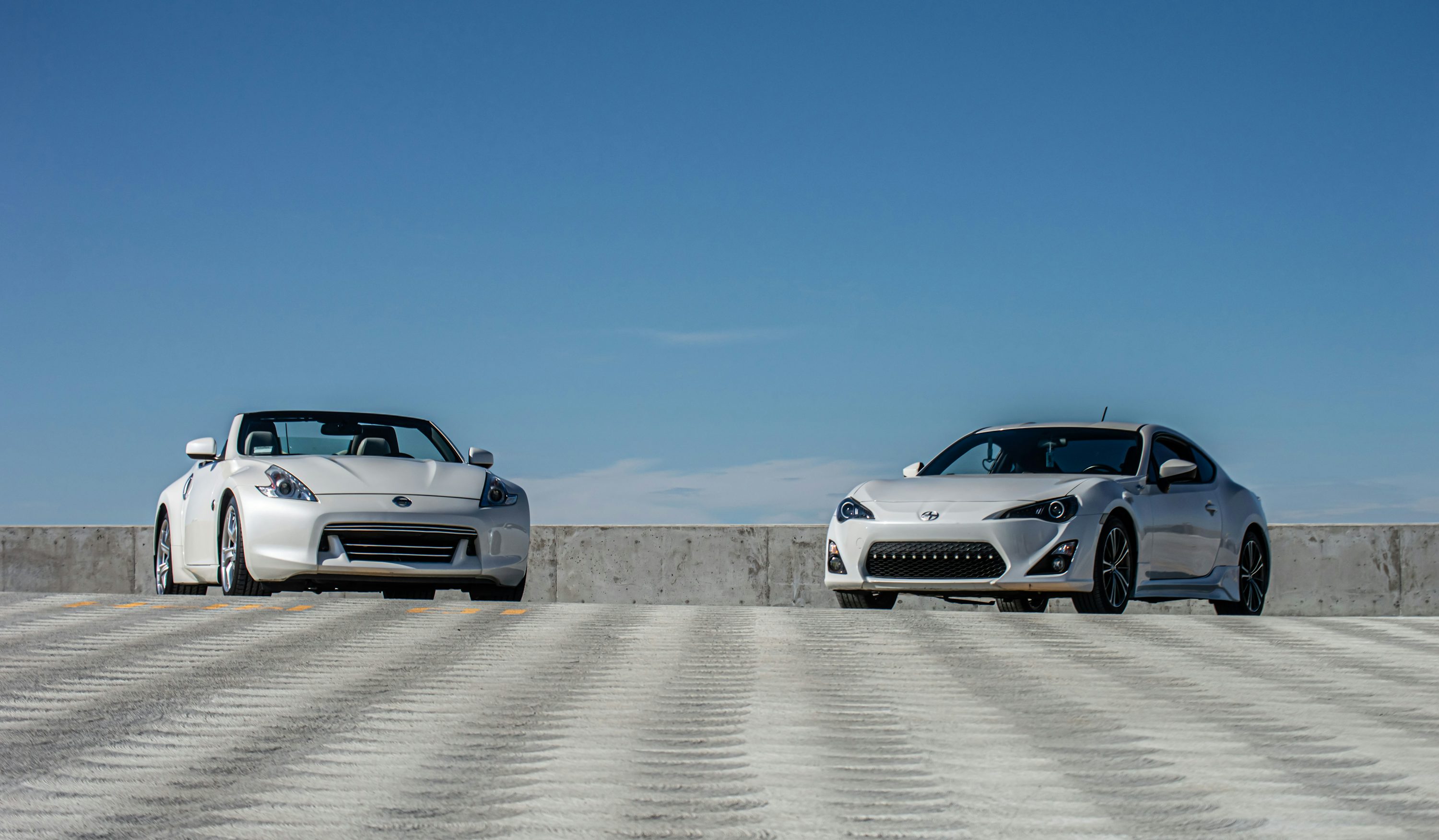 two white sports cars parked next to each other