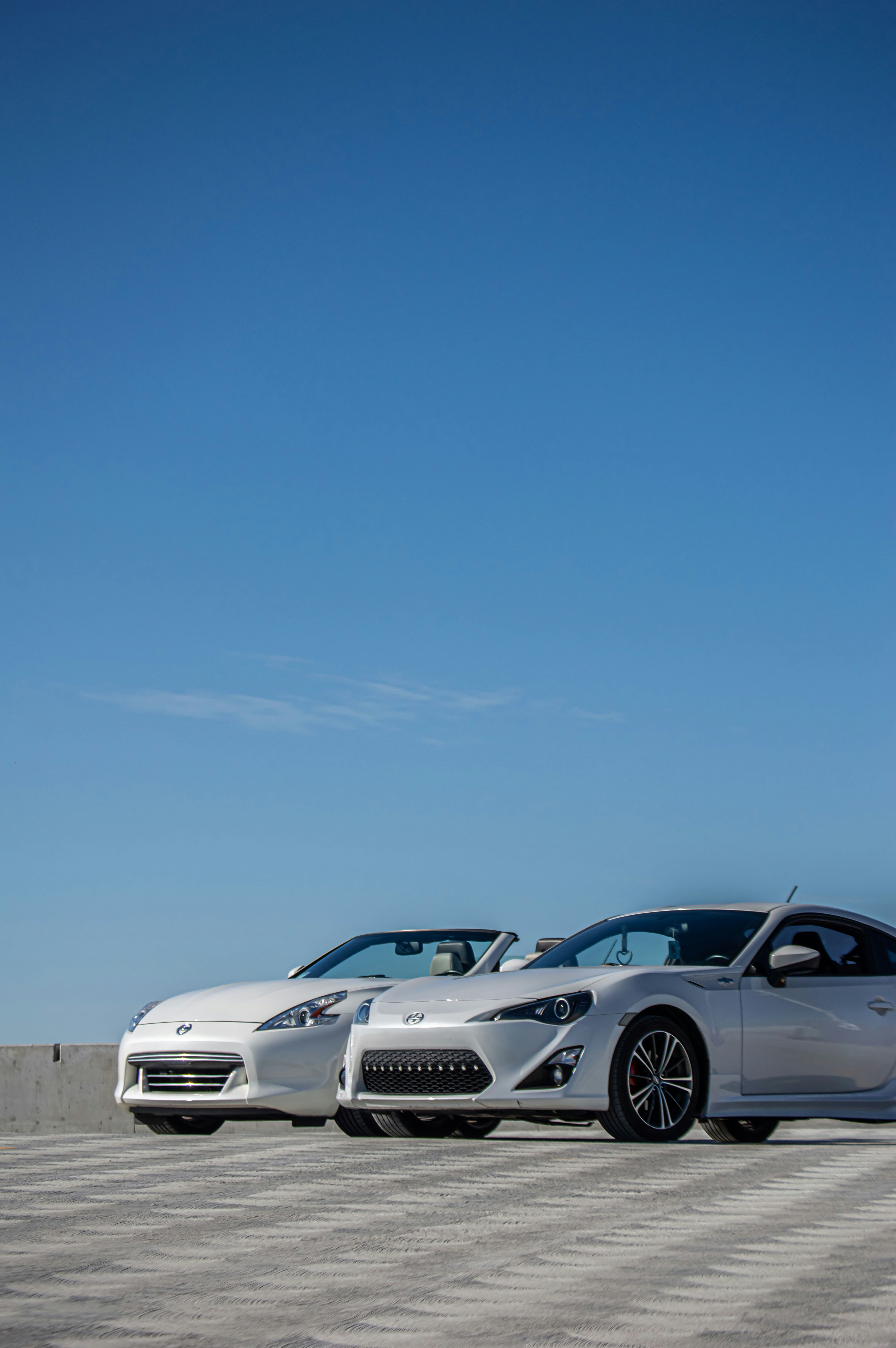 a couple of white cars parked next to each other