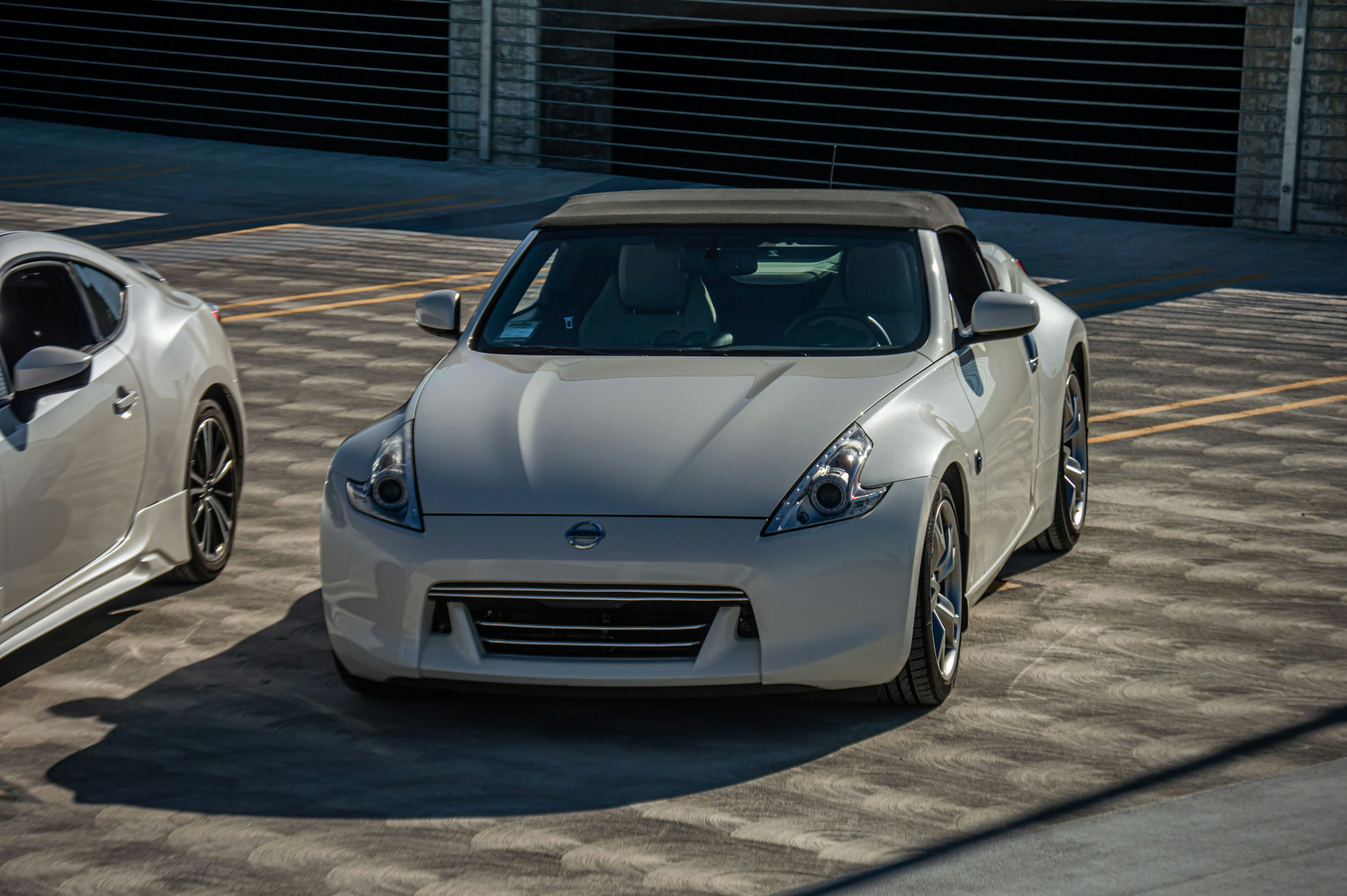 two white sports cars parked in a parking lot