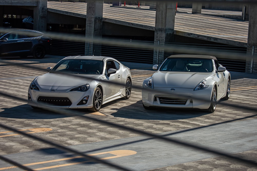 two white sports cars parked next to each other