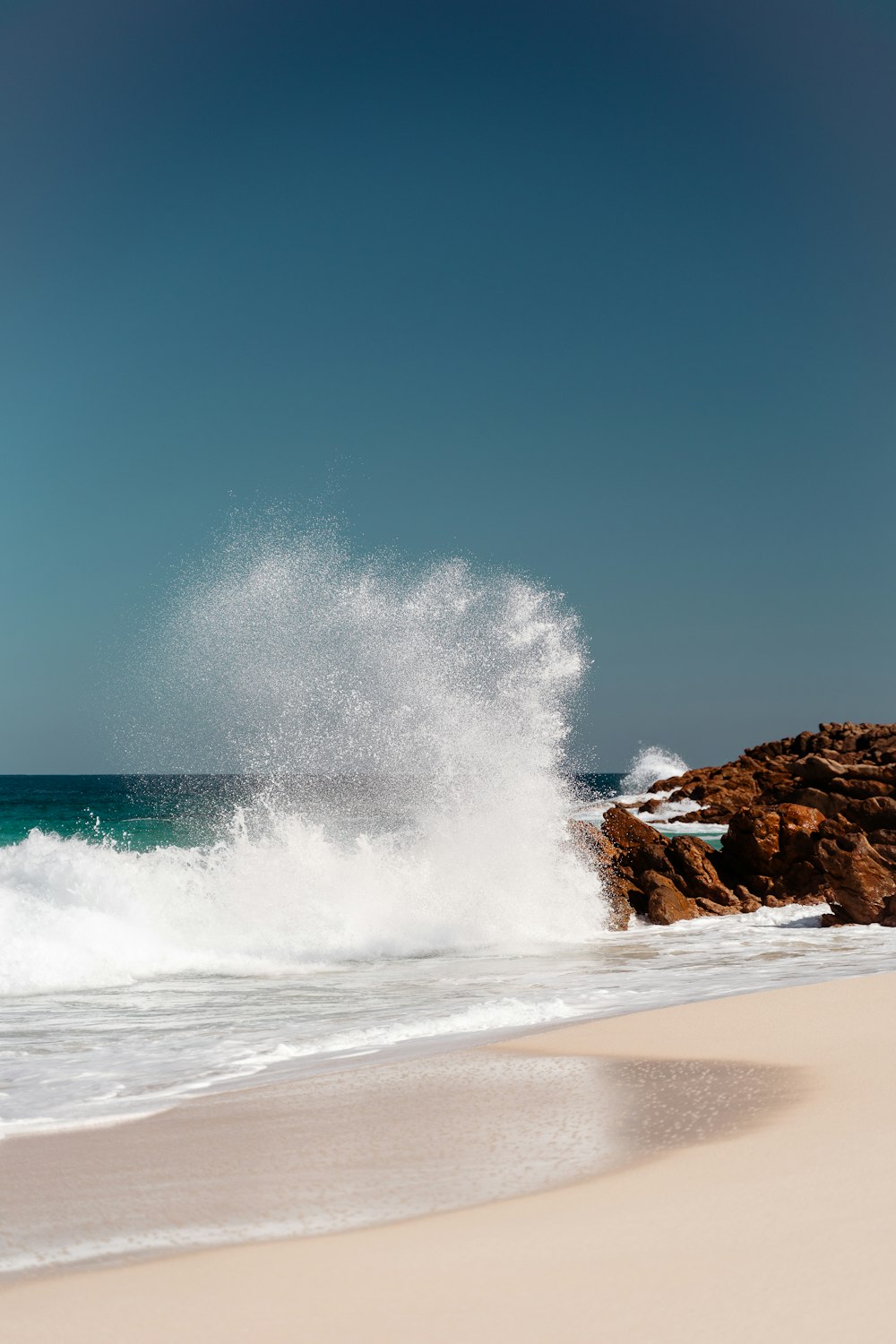 a large wave crashing into the shore of a beach