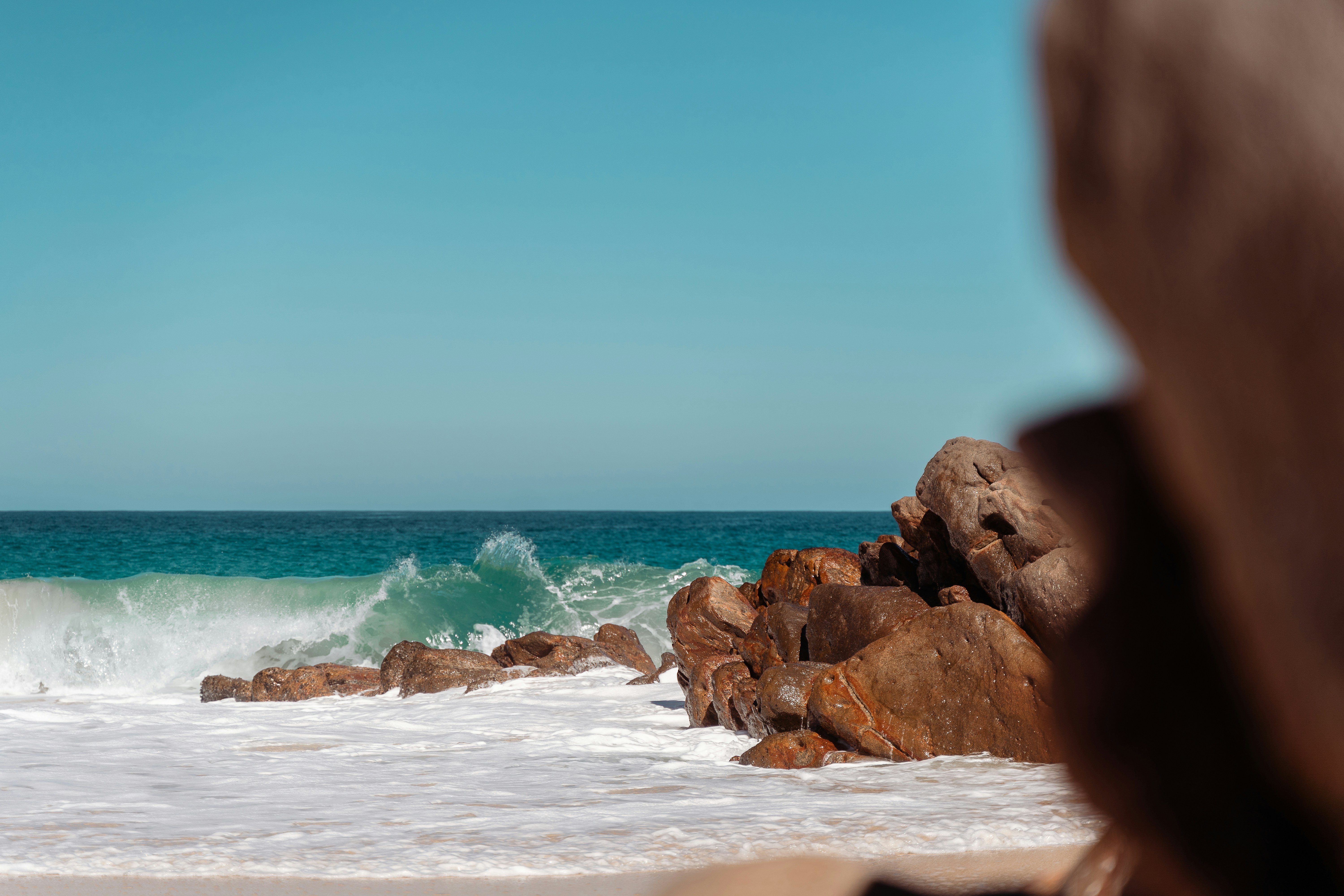 a person standing on a beach with a surfboard