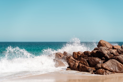a rocky beach with waves crashing against the rocks