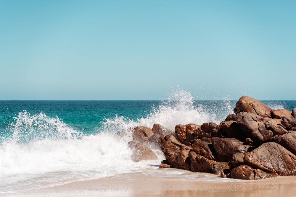 a rocky beach with waves crashing against the rocks