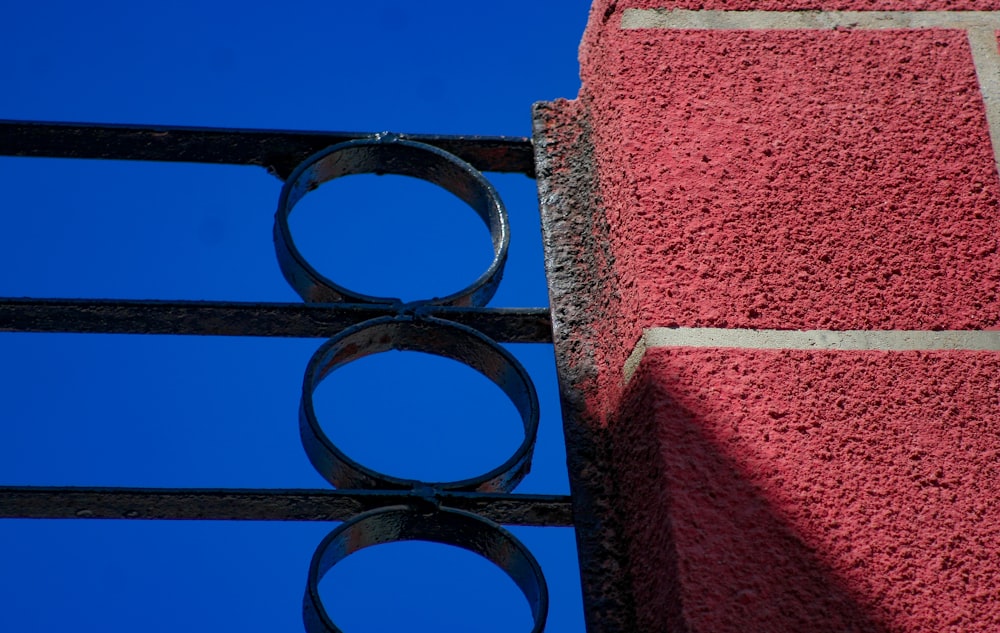 a close up of a metal fence with a blue sky in the background