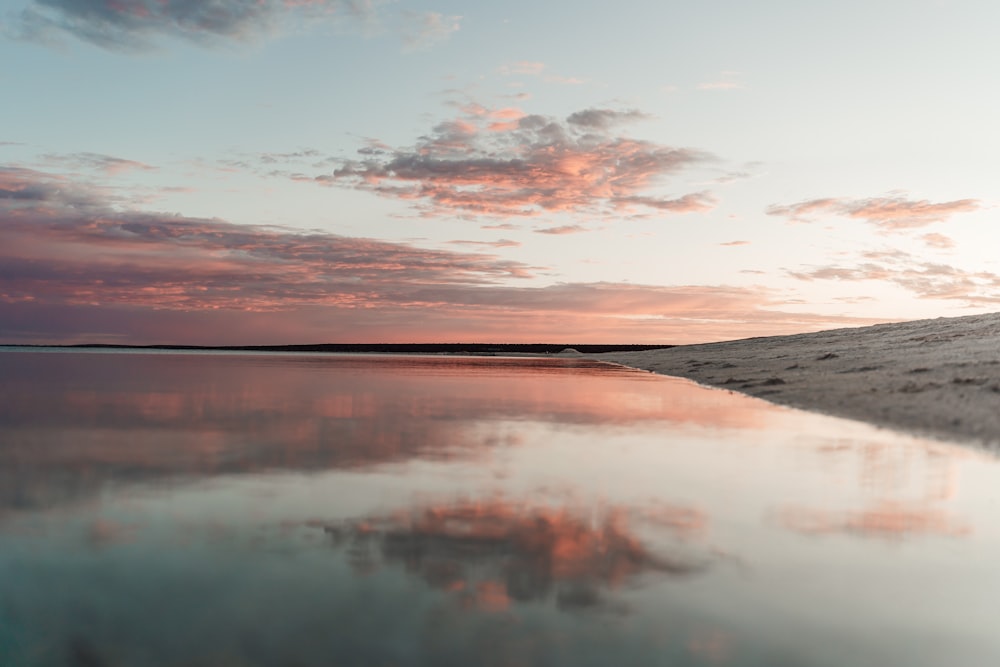 a large body of water sitting under a cloudy sky