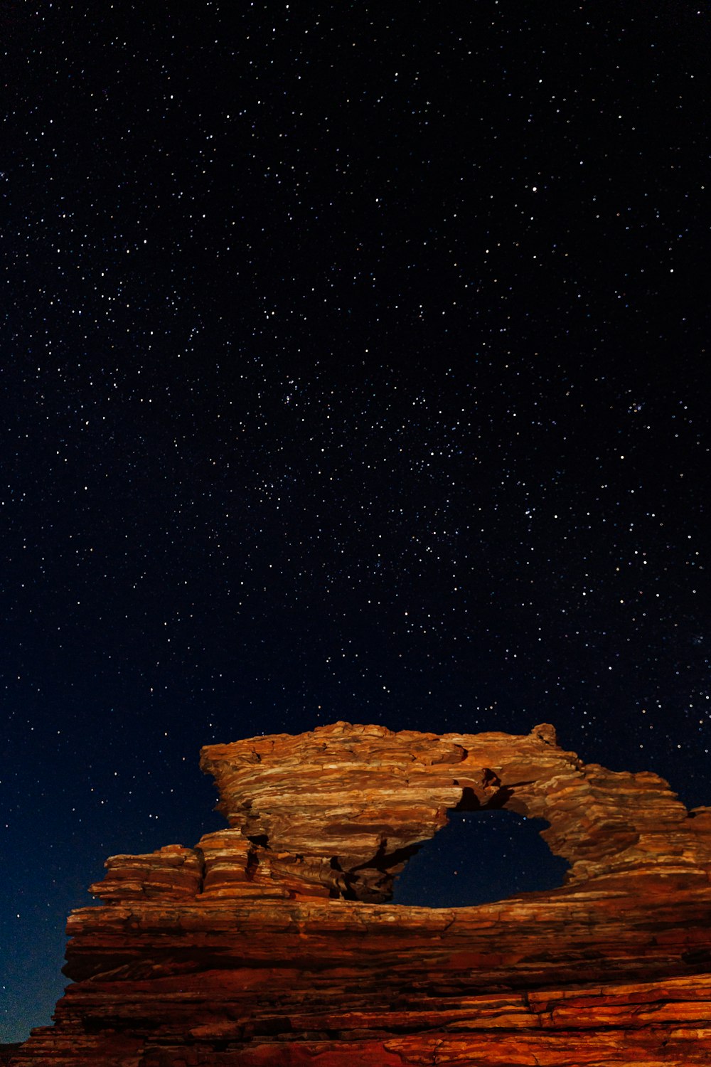 Eine Felsformation unter einem Nachthimmel voller Sterne