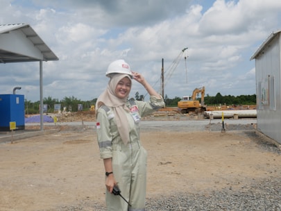 A smiling tradesman holding money in his hands outdoors at a construction site.