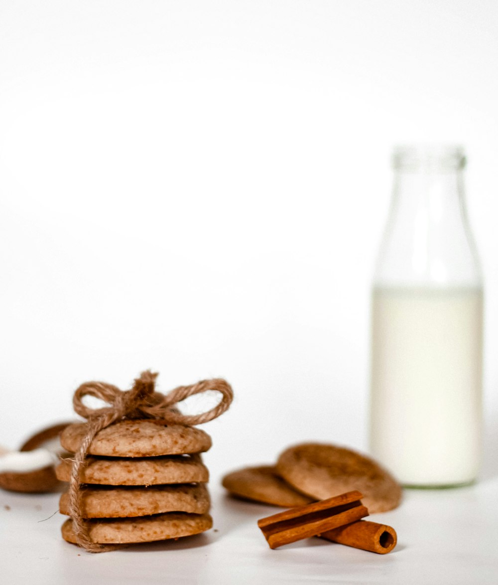 a stack of cookies next to a bottle of milk