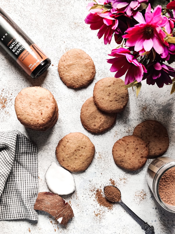 A table topped with cookies next to a vase of flowers