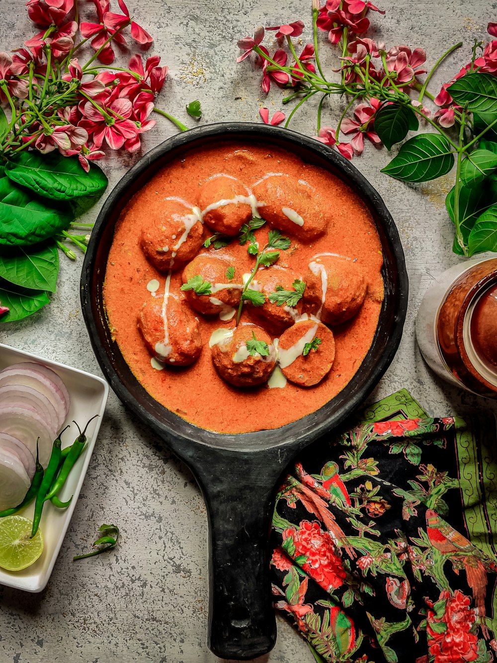 a pan filled with food next to some flowers