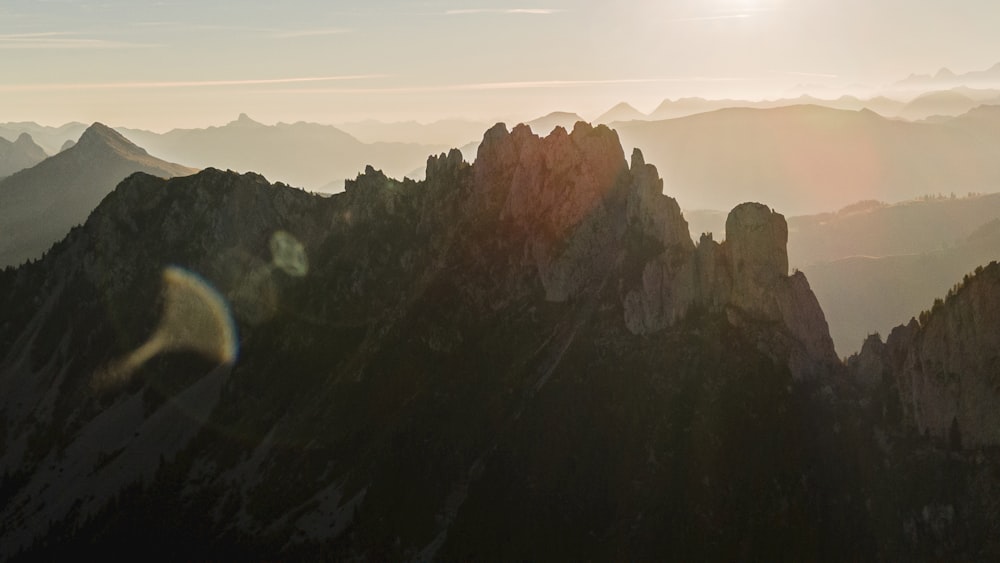 the sun is shining over the mountains in the distance