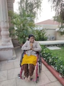 Santiago outdoors in a wheelchair, surrounded by green trees and a clear blue sky