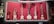 A collection of stringed musical instruments displayed on a vibrant red background. The instruments vary in shape and size, with intricate detailing and diverse structural designs, suggesting traditional craftsmanship.