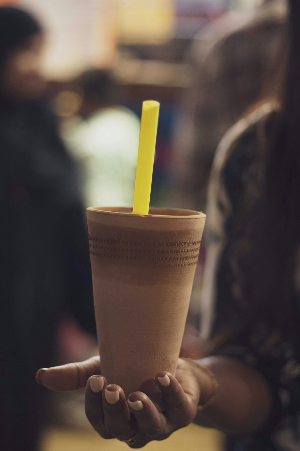 a person holding a cup with a straw in it