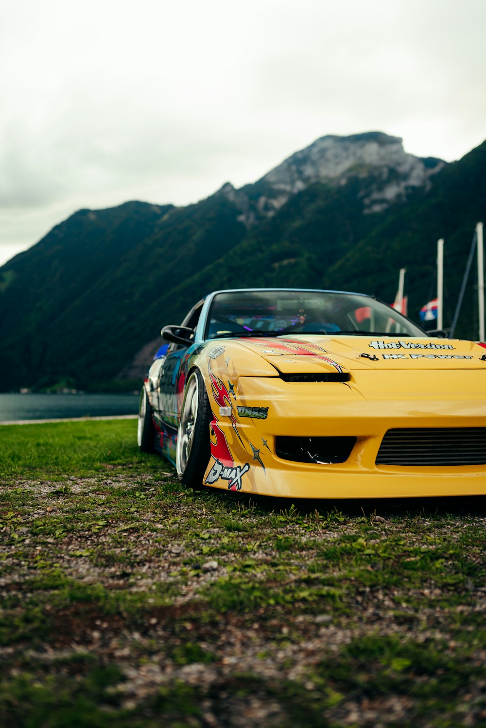 a yellow sports car parked in front of a mountain